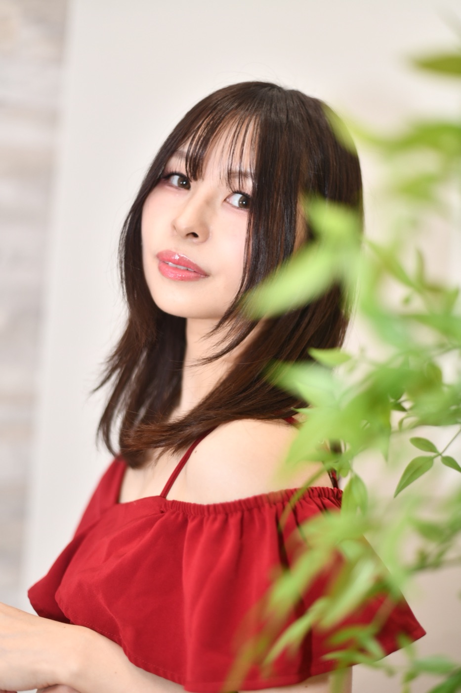 赤いドレスで竹林を背景にほほえむKOYUKIのポートレート
